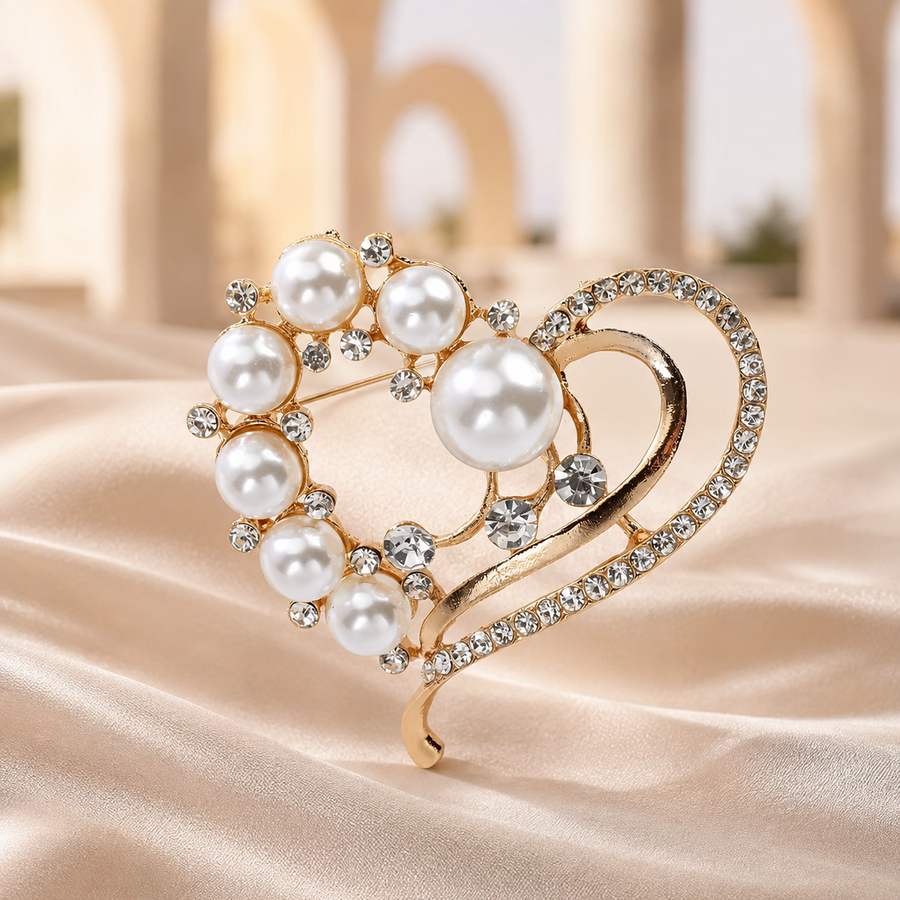 Gold-tone pearl heart brooch on champagne fabric with softly blurred arches