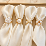 Gold and pearl scarf rings styled on ivory silk